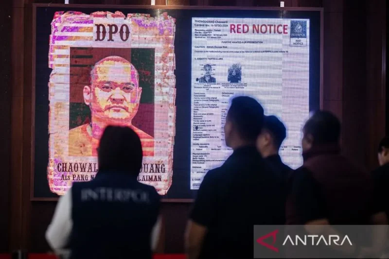 Seorang polisi berada didekat layar yang menampilkan gambar buronan Interpol Thailand Chaowalit Thongduang saat konferensi pers penangkapan buronan Interpol Thailand di Gedung Bareskrim Polri, Jakarta, Minggu (2/6/2024). ANTARA FOTO/Bayu Pratama S/foc/pri.
