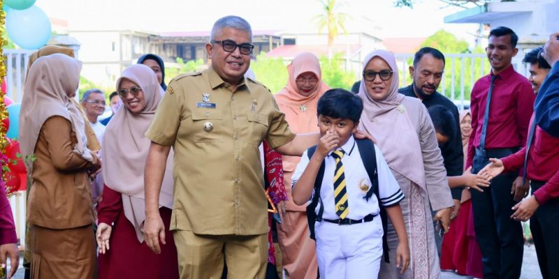 Pj. Gubernur Aceh, Bustami, SE, M.Si, bersama istri yang juga Bunda PAUD Aceh, Mellani Subarni, saat mengantar langsung anaknya pada hari pertama sekolah di SD Al Azhar Cairo Banda Aceh, Senin (15/7/2024) pagi. (foto: humas pemerintah aceh)
