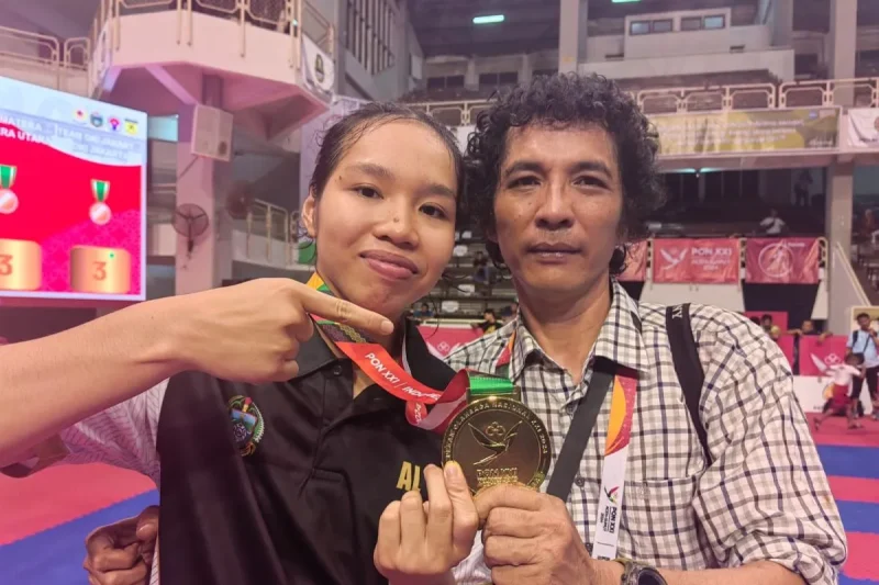 Andi Lubis bersama anaknya, Leica Al Humaira Lubis, berfoto bersama susai pengalungan medali cabang olahraga karate Pekan Olahraga Nasional (PON) XXI Aceh-Sumatera Utara, Rabu (18/9/2024). ANTARA/Asep Firmansyah.
